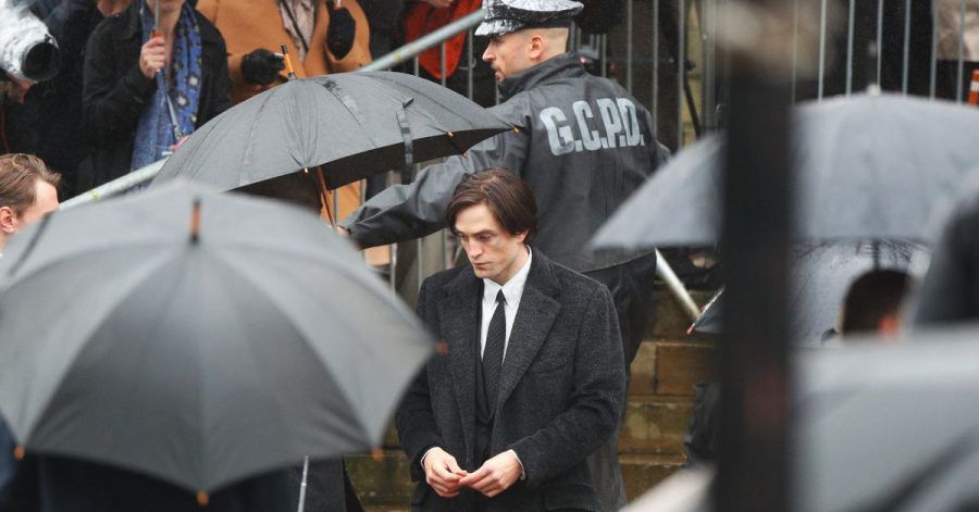 Robert Pattinson steht im Regen.
