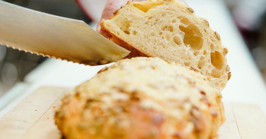 «Fancy-Brot»: Ein Brot mit Kürbis-Käse-Kruste wird in einer Backstube angeschnitten.