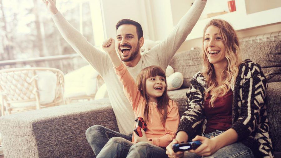 Eine junge Familie, die gemeinsam Videospiele spielt (wue/spot)