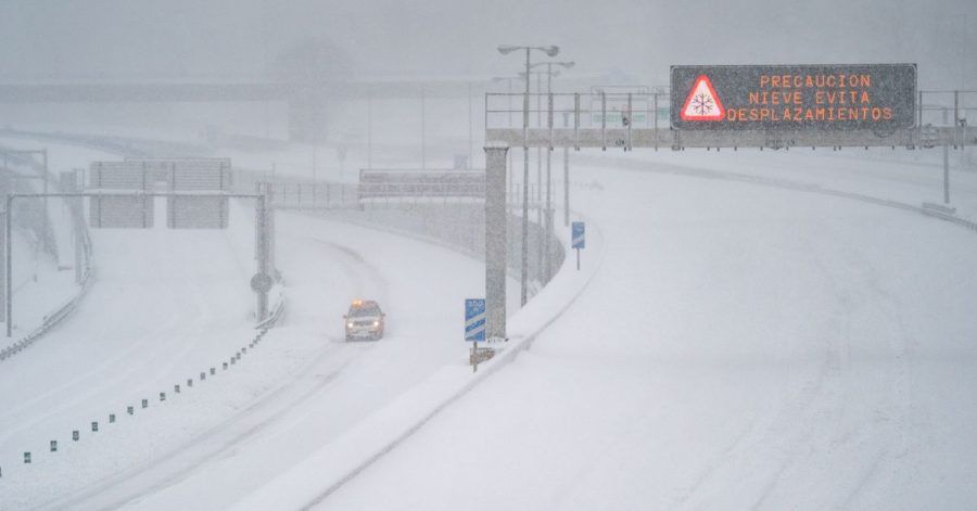 Ein Rettungsfahrzeug fährt auf der leeren, schneebedeckten Schnellstraße M-30 durch Madrid.