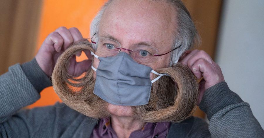 Bart-Weltmeister Jürgen Burkhardt zeigt, wie er seine Schutzmaske aufsetzt.