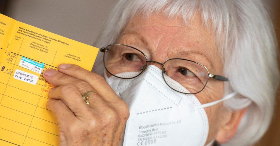 Seniorin Ursula Neuberger hält ihren Impfpass, in dem eine Grippe-Impfung (oben) und ihre erste Corona-Impfung vermerkt sind.