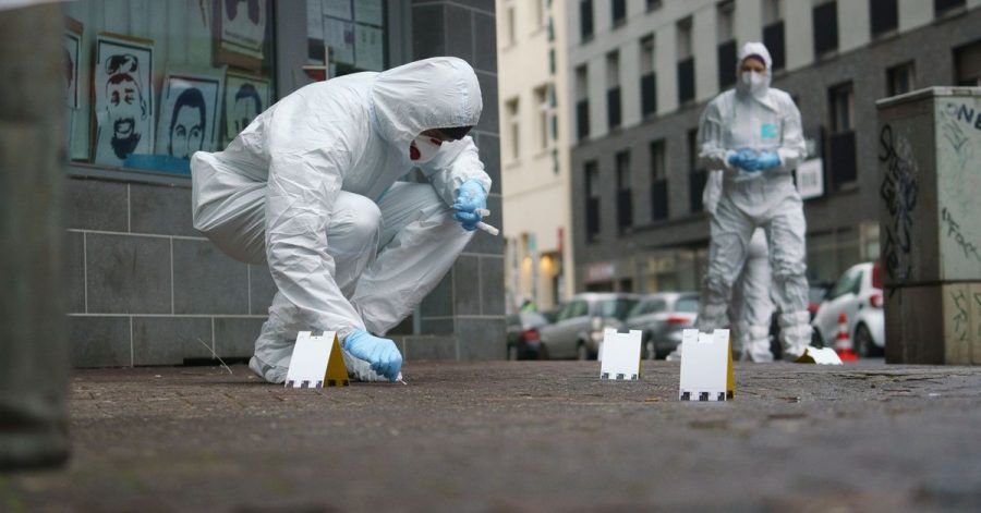 Beamte der Spurensicherung sichern Blutspuren auf dem Gehweg in der Frankfurter Niddastraße.