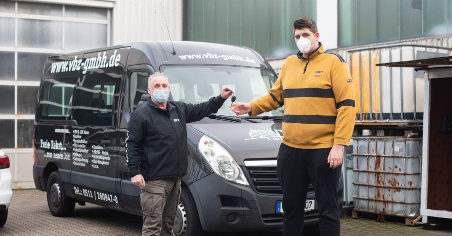 Jannik Könecke (r.) und Jörg Vespermann, Fahrlehrer und Geschäftsführer Berufskraftfahrer-Akademie-Nord GmbH, stehen vor einem für große Fahrschüler umgebauten Fahrzeug.