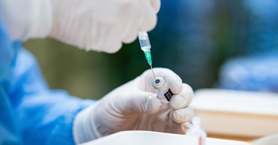 Ein Infektiologe zieht in einem Seniorenheim eine Spritze mit Impfstoff gegen das Coronavirus auf.