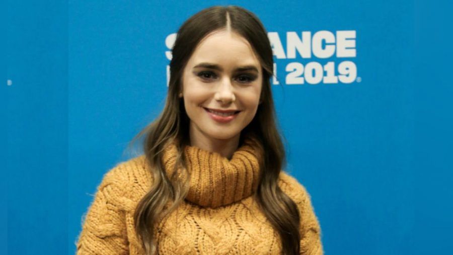 Schauspielerin Lily Collins strahlt im senfgelben Strickpullover. (cos/spot)