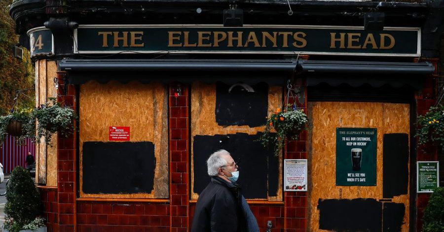 Ein Mann geht an einem geschlossenen Pub in London vorbei.