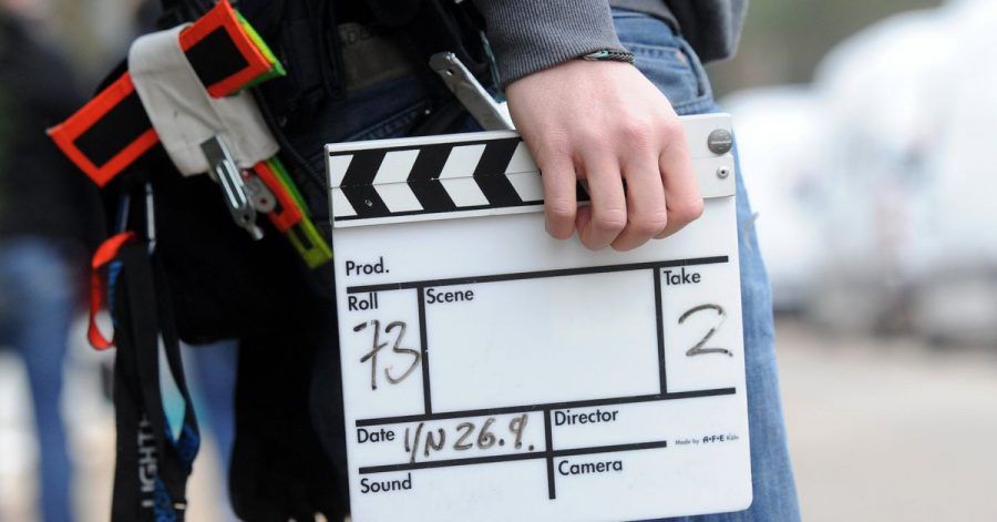 Ein Mitarbeiter eines Filmteams hält eine Filmklappe.