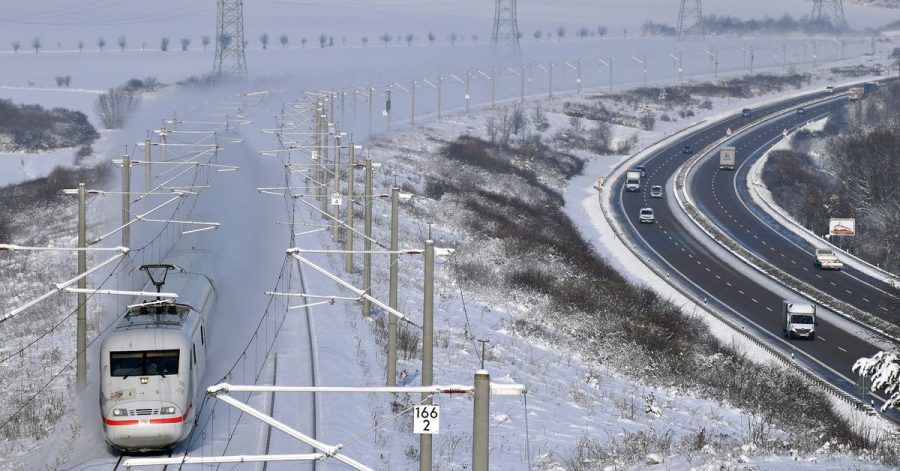 Eisige Zeiten in Thüringen: Ein ICE fährt bei Arnstadt auf der Strecke zwischen Berlin und München entlang der Autobahn A71.