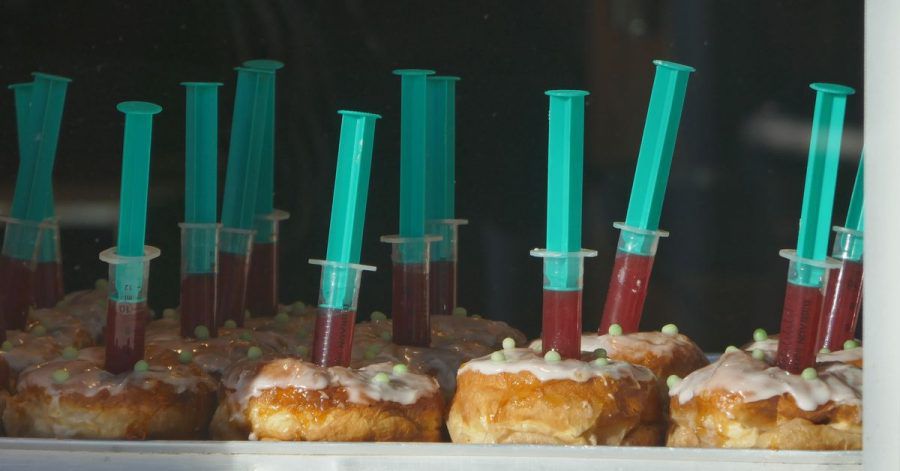 Berliner mit Spritzen, die Erdbeerkonfitüren enthalten, liegen im Schaufenster eines Bäckers in Haan.