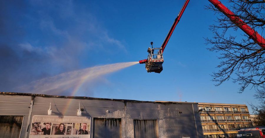 Feuerwehrleute bekämpfen den Brand von einer Drehleiter aus.