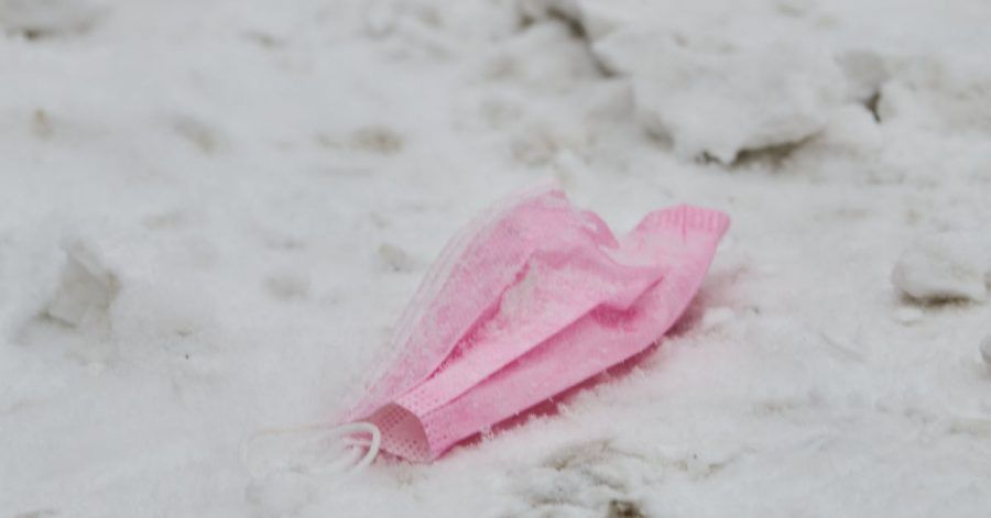 Eine pinke Maske liegt im Schnee.