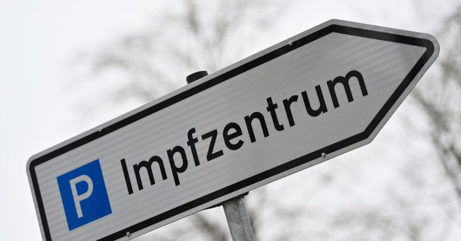 Ein Wegweiser zeigt zum Parkplatz für ein Impfzentrum. In Sachsen sind 2500 Impftermin unbesetzt.