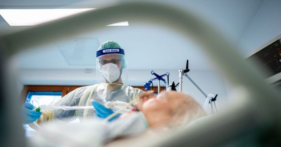 Ein Intensivpfleger arbeitet in Schutzausrüstung auf der Intensivstation des Krankenhauses Bethel in Berlin an einem Corona-Patienten.