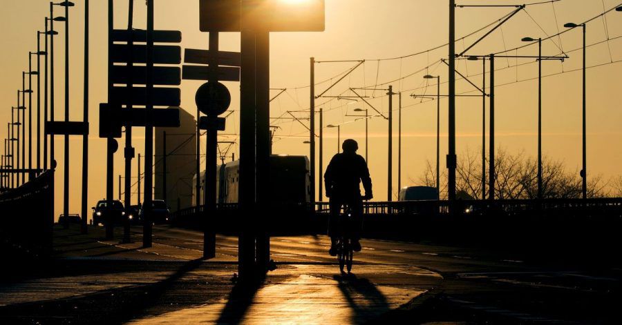 Ein Radfahrer fährt über die Deutzer Brücke in Köln. Die Zahl der Corona-Neuinfektionen steigt.