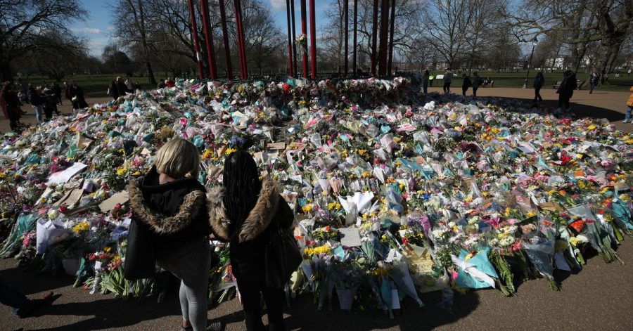 Zwei Frauen schauen sich die Blumen an, die für die getötete Sarah Everard im Clapham Common Park in London niedergelegt wurden.