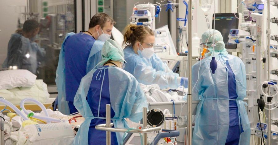 Ärztinnen, Ärzte und Pflegende arbeiten auf der Corona-Intensivstation der Charité am Bett einer jungen Patientin.