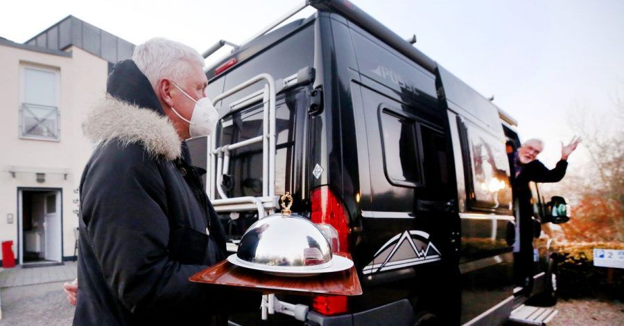 Hans-Werner Scherer (l.), Gastwirt des Restaurantes Bootshaus Ruhreck", bringt seinem Kunden Hubert eine Vorspeise zu seinem Wohnmobil.