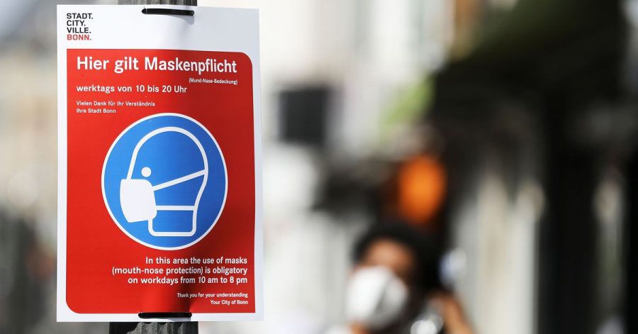 Ein Schild mit der Aufschrift "Hier gilt Maskenpflicht" hängt in der Fußgängerzone.