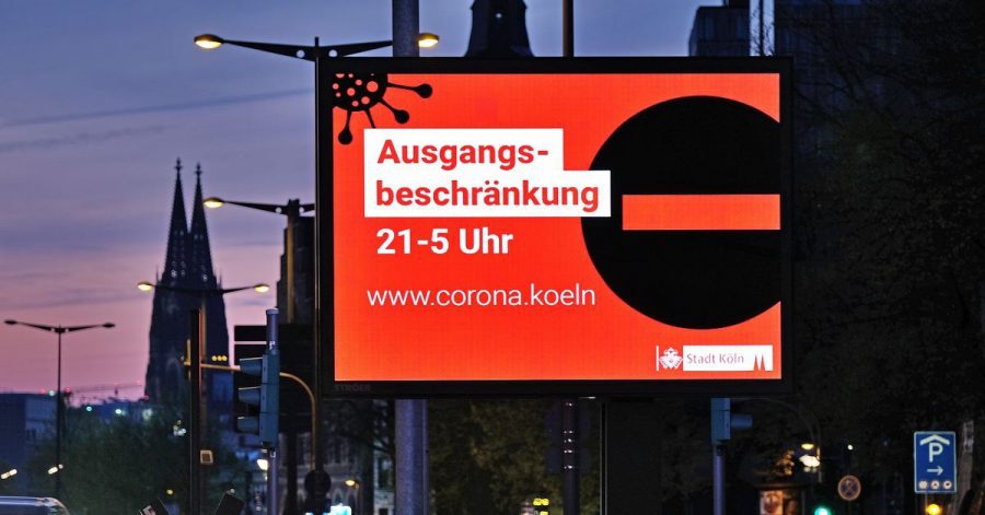 Auf einer Anzeigetafel in Köln wird auf die Ausgangsbeschränkung hingewiesen.