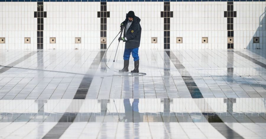 Ein Mitarbeiter reinigt ein Becken im Inselbad Untertürkheim in Stuttgart.