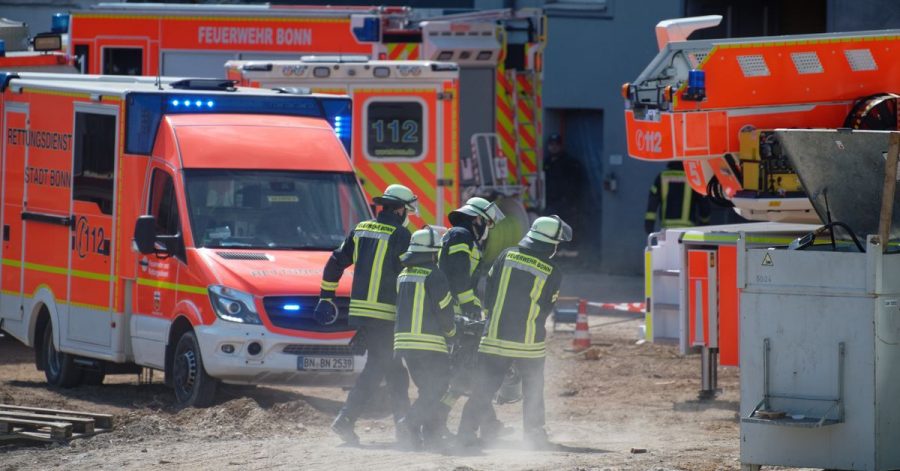 Feuerwehrleute tragen ihre Ausrüstung zur Einsatzstelle auf die Baustelle.