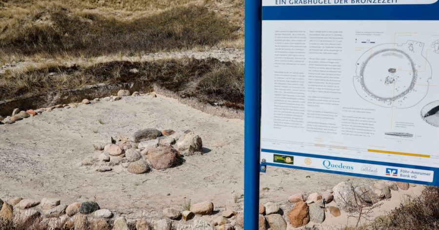 Ein Grabhügel aus der Bronzezeit ist als Denkmal in den Dünen am Strand zu sehen.