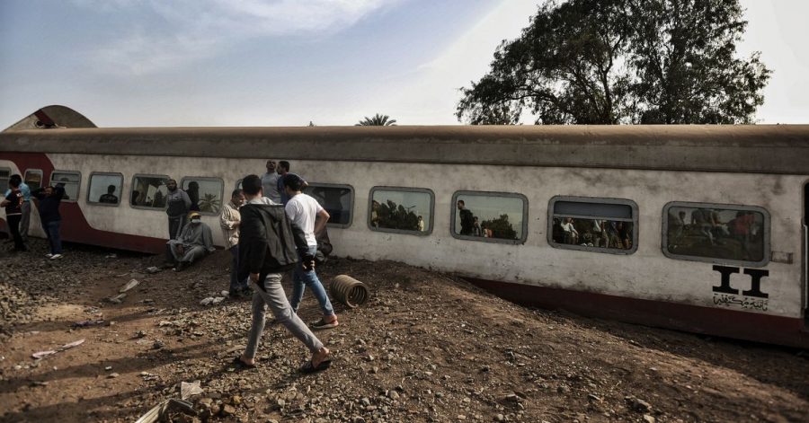 Menschen gehen an einem entgleisten Waggon in der Provinz Kaljubia vorbei.