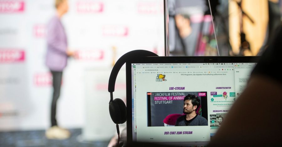 Ein Zuschauer des Festivals folgt einem Interview mit den Geschäftsführern auf der Bühne.