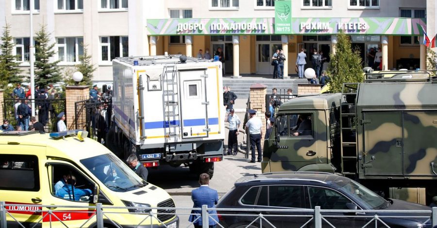 Ein Krankenwagen und Polizeifahrzeuge stehen nach einem Angriff mit Schusswaffen vor einer russischen Schule in Kasan.