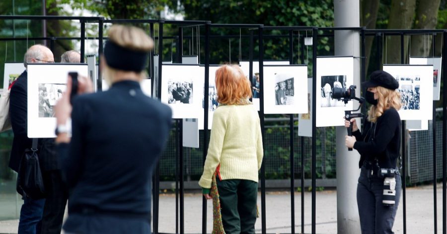 Spaziergänger schauen sich die Outdoor-Fotoausstellung im Rahmen der Ruhrfestspiele am Festspielhaus an.