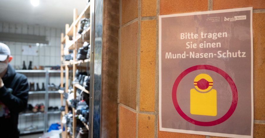 In der Kleiderkammer der Berliner Stadtmission hängt ein Plakat mit der Aufschrift „Bitte tragen Sie einen Mund-Nasen-Schutz“.