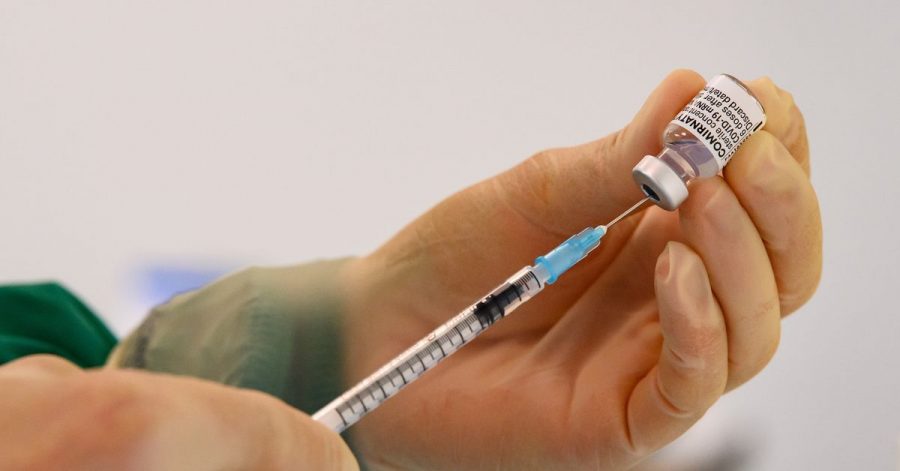 Eine Pharmazeutisch-technische Assistenten zieht eine Spritze mit dem Corona-Impfstoff von Biontech/Pfizer auf.