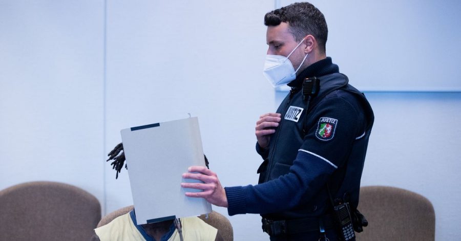 Der Angeklagte wird in Handschellen in einen Gerichtssaal im Landgericht Köln geführt.
