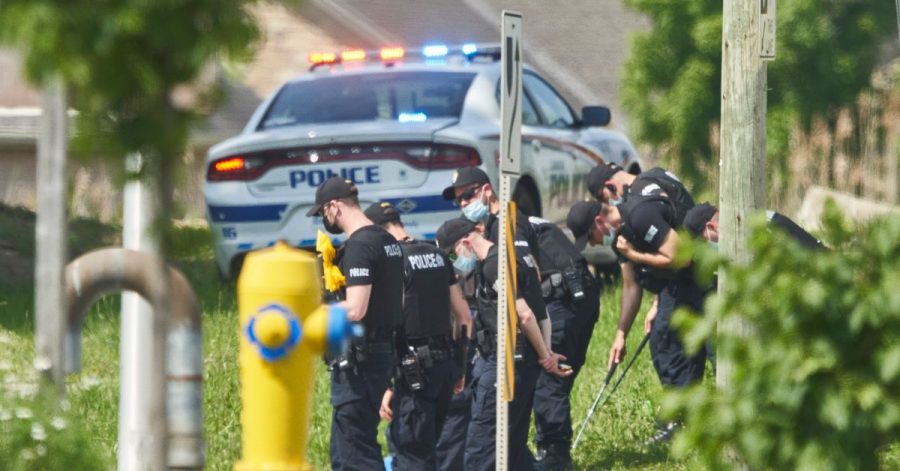 Polizisten in Reihe untersuchen den Tatort eines Autounfalls in London, Ontario. Nach einem Angriff mit einem Auto, bei dem vier Menschen aus einer muslimischen Familie getötet worden sind, geht die Polizei Berichten zufolge von einem rassistischen Tatmotiv aus.