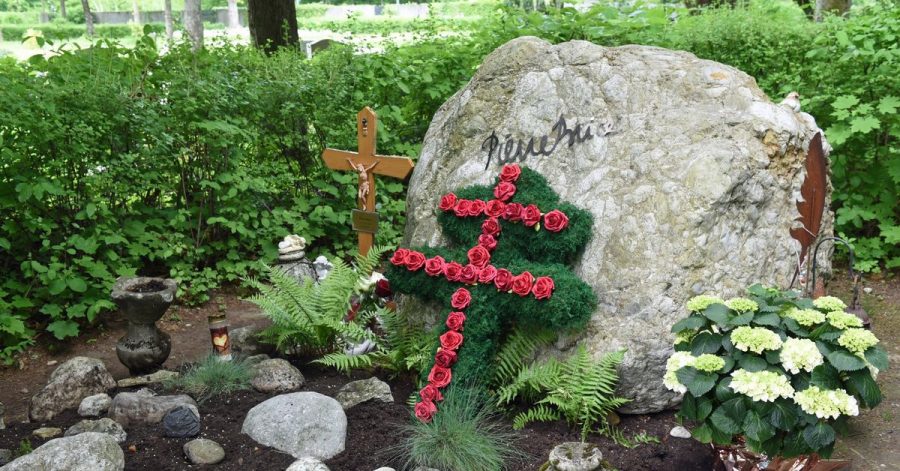 Ein Lothringer Kreuz aus roten Rosen und ein großer Felsbrocken schmücken das Grab des französischen Schauspielers Pierre Brice.