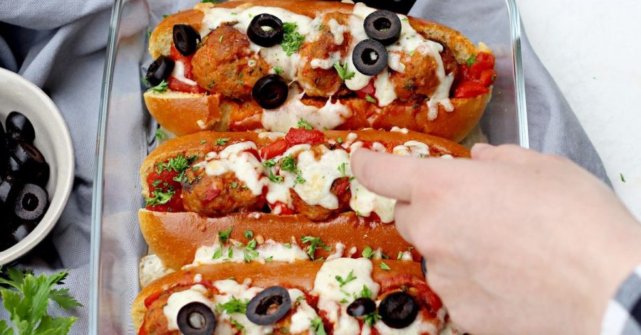 Bevor die Meatball Sandwiches im Ofen für 10 Minuten mit Mozzarella überbacken werden, kommen in jedes Briochebrötchen 3 Hackbällchen und etwas Soße.