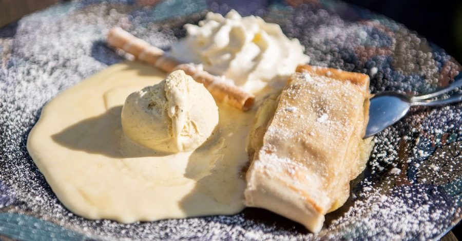 Der Klassiker unter den Strudeln ist der Apfelstrudel. Hier wird er mit Vanilleeis und Sahne und Puderzucker serviert.