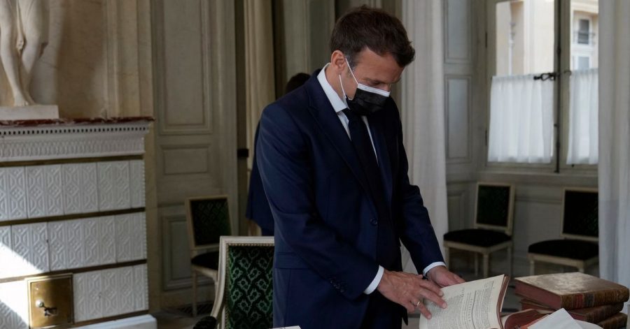 Präsident Emmanuel Macron blättert in alten Büchern.