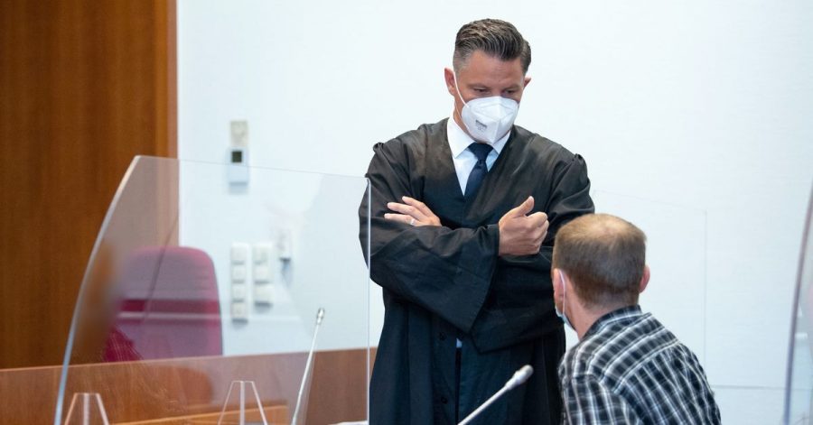 Einer der Angeklagten (r) unterhält sich vor Prozessbeginn mit seinem Verteidiger Dietmar Bonn.