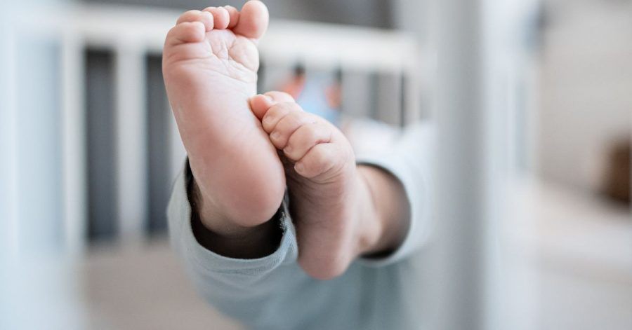Die Füße eines Babys sind in einem Kinderbett zu sehen. Im vergangenen Jahr wurden in Deutschland weniger Kinder geboren als im Jahr davor. Laut dem Statistischen Bundesamt liegt das vor allem daran, dass die Zahl der Frauen im gebärstarken Alter erstmalig seit 2011 leicht zurückging.