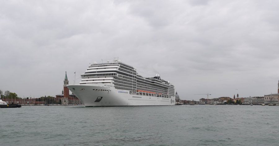 Ein Kreuzfahrtschiff fährt an der Lagunenstadt Venedig von einem Schlepper gezogen vorbei.