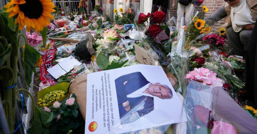 Menschen haben Bilder des Kriminalreporters und Blumen am Tatort niedergelegt.