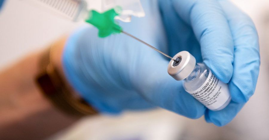Eine Klinik-Mitarbeiterin zieht den Covid-19 Impfstoff von Biontech/Pfizer für eine Impfung auf eine Spritze.