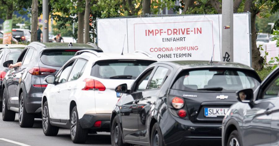 Eine lange Schlange bildet sich vor der Einfahrt zur Impfung an der Ikea-Filiale Lichtenberg vor dem Schild mit der Aufschrift "Impf-Drive-In Einfahrt Corona-Impfung Ohne Termin".