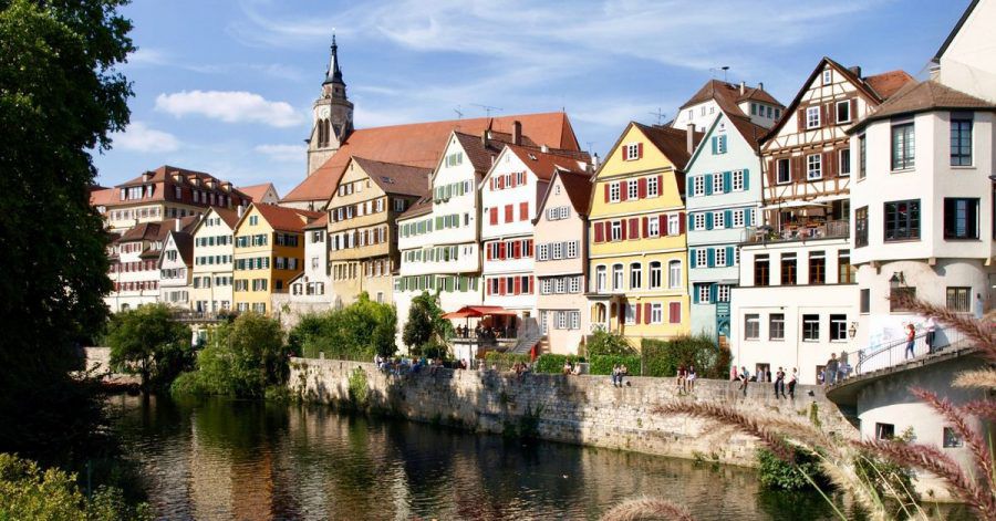 Der Bootsführer im Stocherkahn erklärt Touristen die Neckarfront in Tübingen.