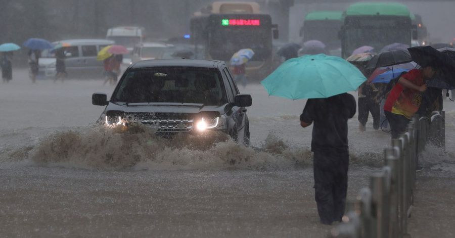 Ein Auto fährt in der zentralchinesischen Provinz Henan über eine überflutete Straße.