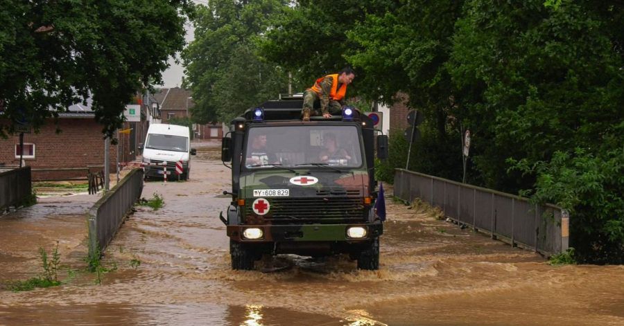 In Erftstadt bahnt sich ein Fahrzeug der Bundeswehr einen Weg durch eine überflutete Straße.