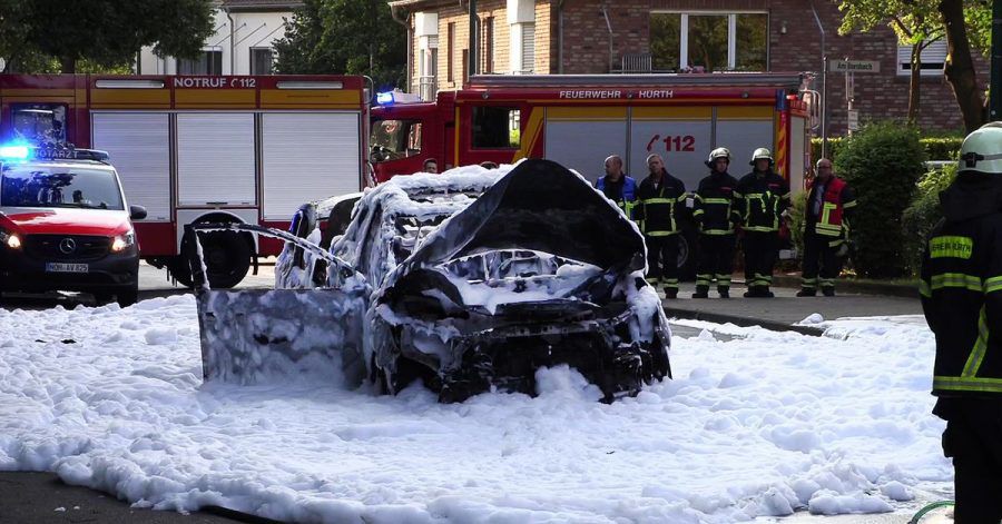 Vom Löschschaum bedeckt steht ein Auto nach einer Explosion auf der Straße im nordrhein-westfälischen Hürth.