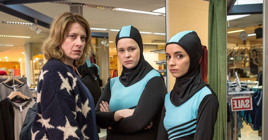 Wanda (Caroline Peters) kauft für ihre Tochter Nina (Chantal Zitzenbacher, M) und deren beste Freundin Maryam (Duygu Arslan) einen Burkini.